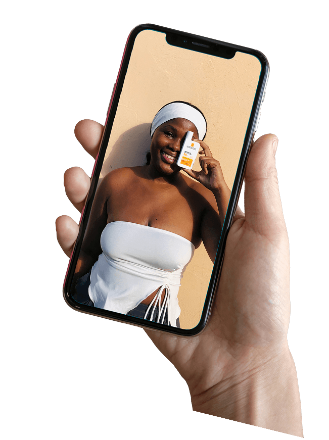 Hand holding a phone showing a UGC creator with a skincare product