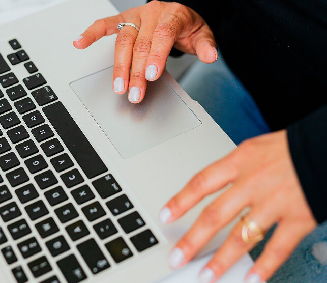 Hands using a laptop to review campaign performance
